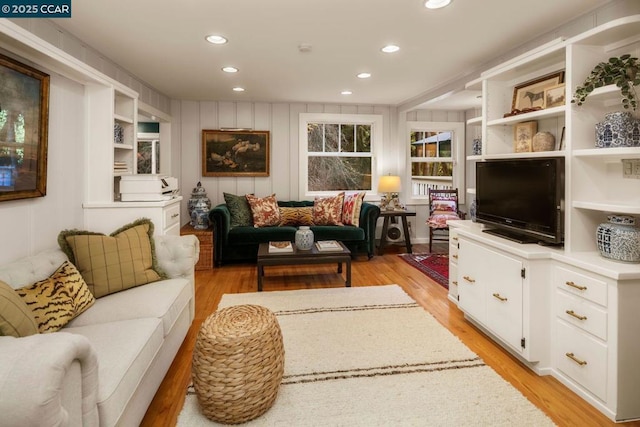 living room featuring built in shelves and light hardwood / wood-style floors