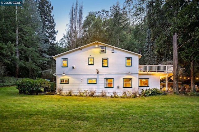 rear view of house with a wooden deck and a yard