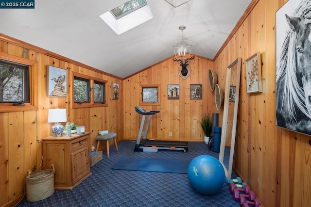 workout room with ornamental molding, wooden walls, lofted ceiling with skylight, and carpet flooring