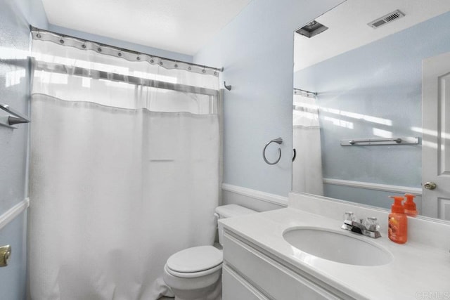 bathroom featuring a shower with curtain, vanity, and toilet