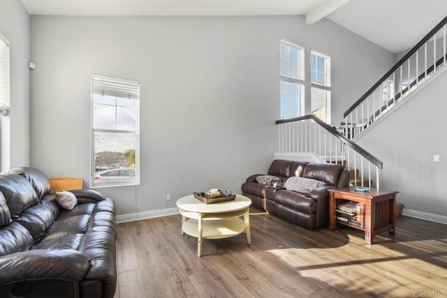 living room featuring hardwood / wood-style flooring, high vaulted ceiling, and beam ceiling