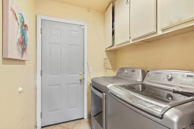 laundry room featuring cabinets, washing machine and clothes dryer, and light tile patterned flooring