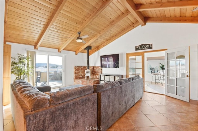 tiled living room featuring beamed ceiling, wood ceiling, high vaulted ceiling, and a wood stove