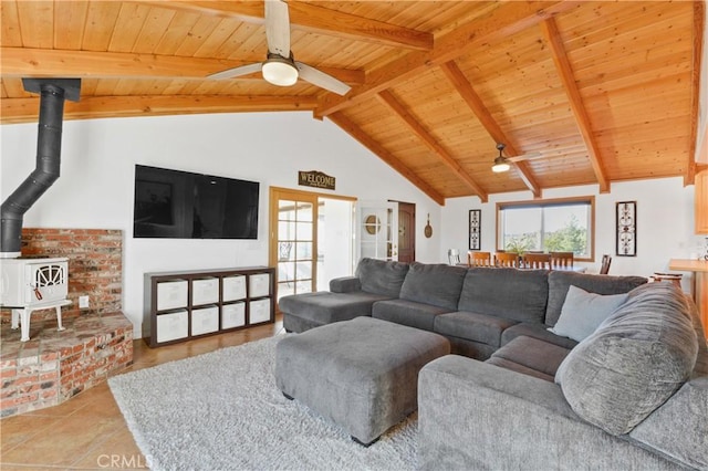 tiled living room featuring beam ceiling, wood ceiling, ceiling fan, and a wood stove