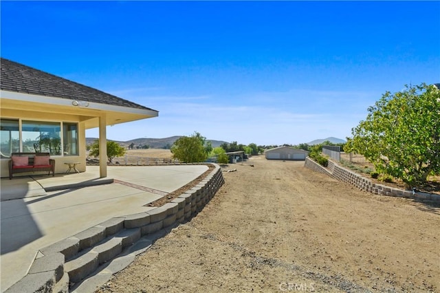 view of yard featuring a mountain view and a patio area