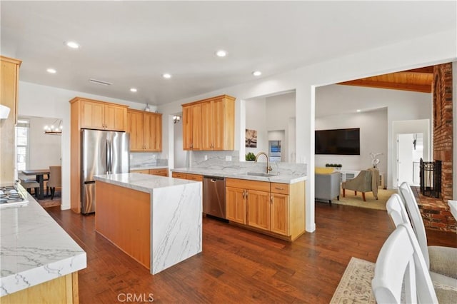 kitchen featuring sink, vaulted ceiling with beams, tasteful backsplash, a center island, and stainless steel appliances