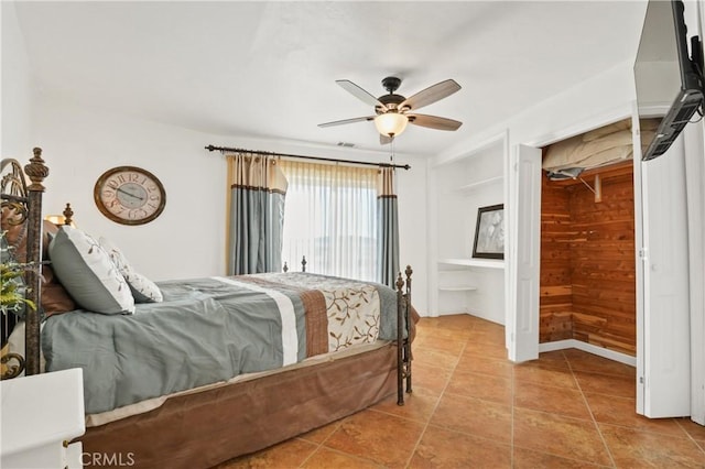 tiled bedroom with wooden walls and ceiling fan