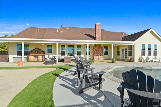 back of house featuring an outdoor kitchen, outdoor lounge area, a patio, and french doors