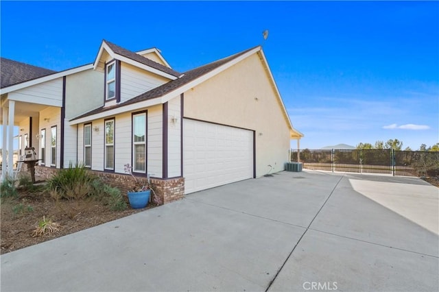 view of property exterior featuring central AC unit and a garage