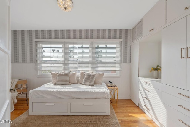 bedroom with light hardwood / wood-style floors and multiple windows