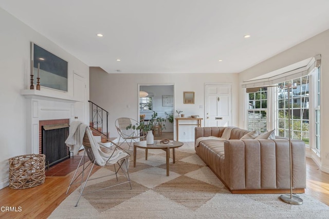 living room featuring light hardwood / wood-style floors and a brick fireplace