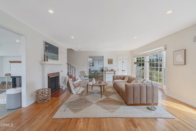 living room featuring light hardwood / wood-style floors and a brick fireplace