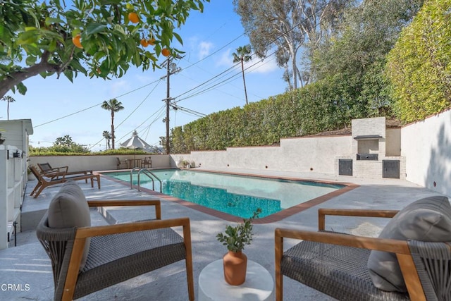 view of swimming pool with an outdoor fireplace and a patio