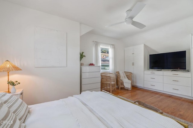 bedroom with hardwood / wood-style flooring, vaulted ceiling, and ceiling fan