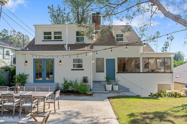 back of property featuring a yard, a sunroom, a patio, and french doors