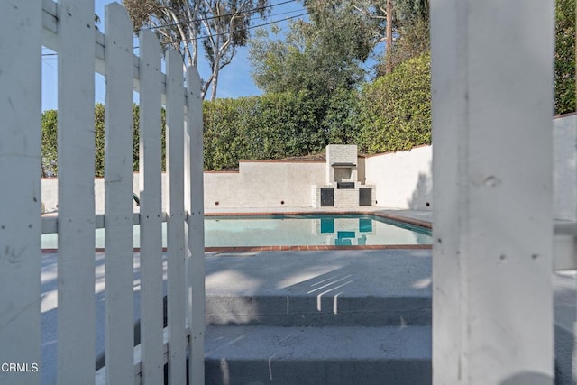 view of pool with a fireplace and a patio