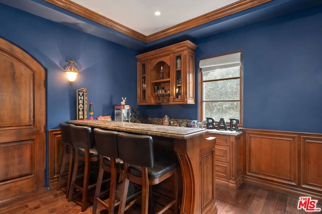 bar with dark wood-type flooring and ornamental molding