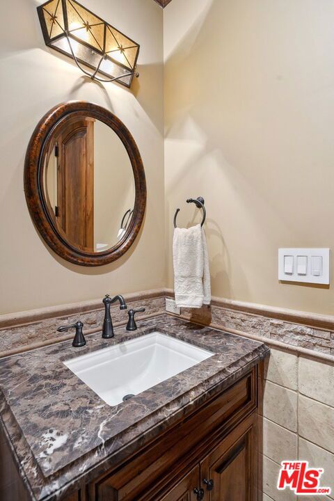 bathroom with vanity and tile walls