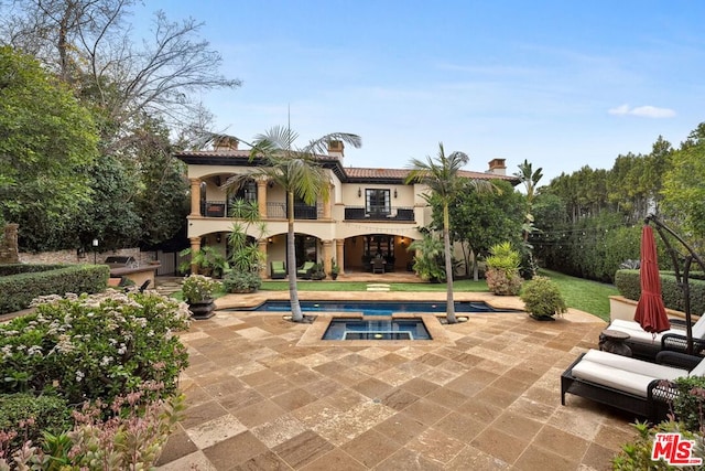 exterior space with an in ground hot tub, outdoor lounge area, and a patio area