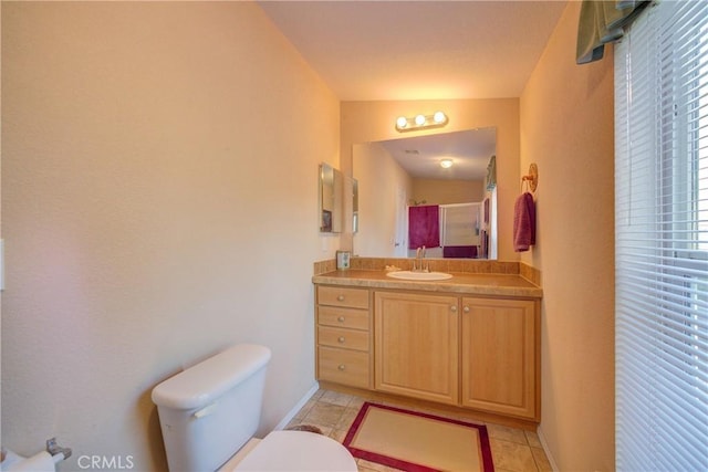 bathroom with tile patterned floors, vanity, toilet, and a shower with door