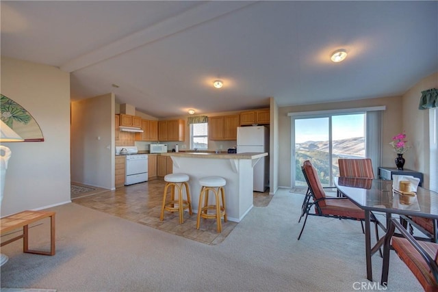 kitchen with a center island, lofted ceiling with beams, light colored carpet, a mountain view, and white appliances