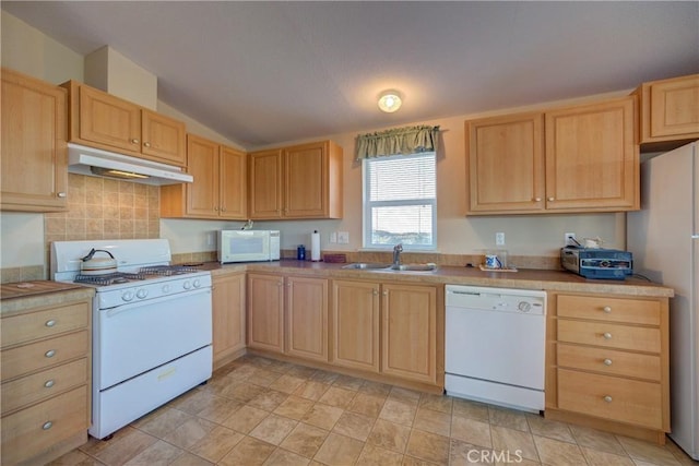 kitchen featuring sink, vaulted ceiling, light brown cabinets, white appliances, and decorative backsplash