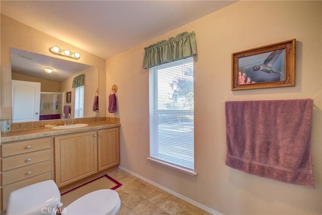 bathroom featuring vaulted ceiling, a shower with shower door, vanity, toilet, and tile patterned floors