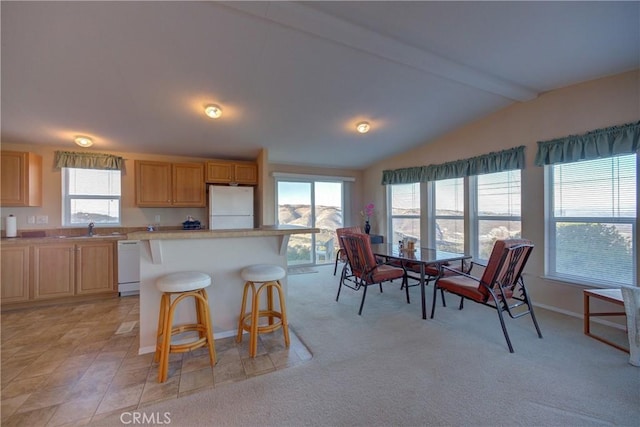 kitchen with sink, a breakfast bar area, a center island, lofted ceiling with beams, and white appliances