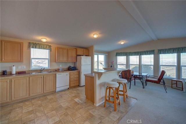 kitchen featuring sink, white appliances, a breakfast bar, lofted ceiling with beams, and a kitchen island