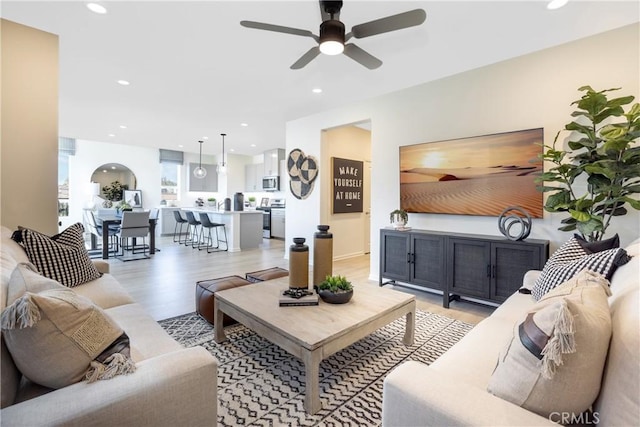 living room featuring ceiling fan and light wood-type flooring