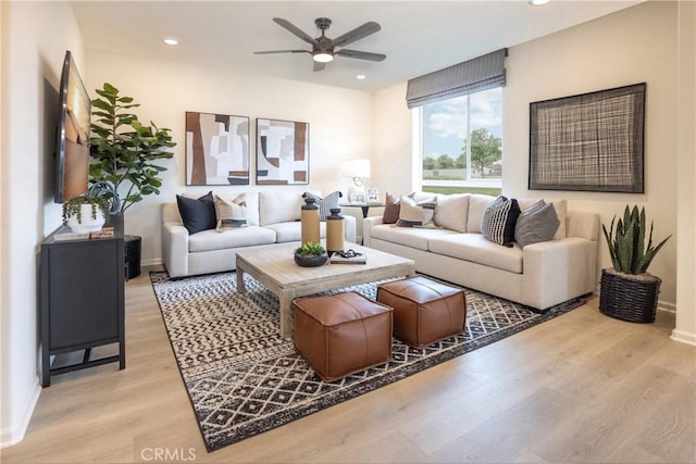 living room featuring light hardwood / wood-style flooring and ceiling fan