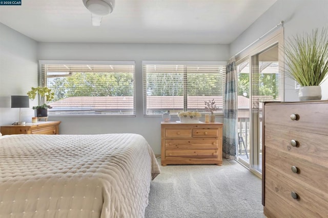 carpeted bedroom with multiple windows and access to outside