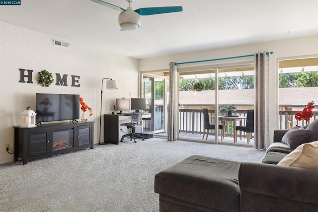 carpeted living room with ceiling fan