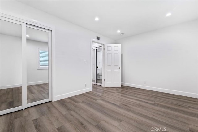 unfurnished bedroom with wood-type flooring and a closet