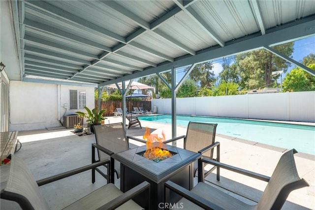 view of patio featuring a fenced in pool, central AC, and a fire pit