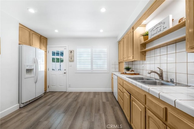 kitchen with tile countertops, tasteful backsplash, sink, dark wood-type flooring, and white appliances