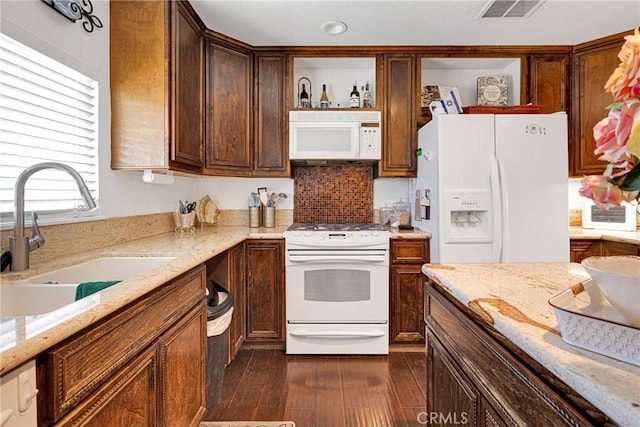 kitchen featuring light stone counters, sink, white appliances, and dark hardwood / wood-style flooring