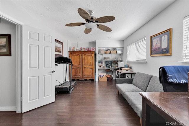 living room with dark wood-type flooring, ceiling fan, and a textured ceiling