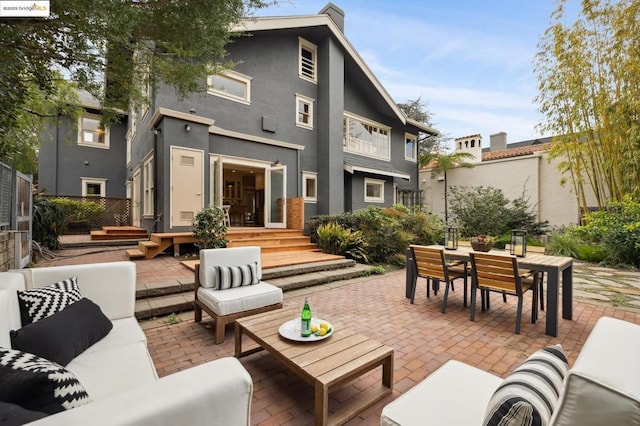 back of house with an outdoor living space and a patio