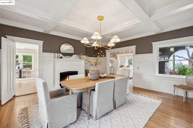 dining space with beamed ceiling, wood-type flooring, coffered ceiling, and a chandelier