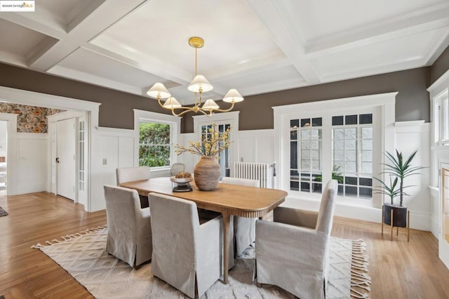 dining space featuring coffered ceiling, a notable chandelier, beam ceiling, and light hardwood / wood-style floors