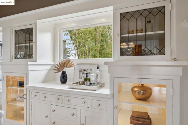 bar with white cabinetry and a fireplace