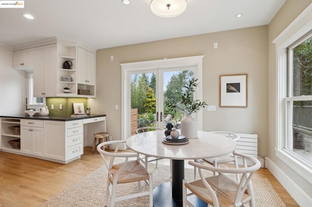 dining area featuring built in desk, light hardwood / wood-style floors, and french doors