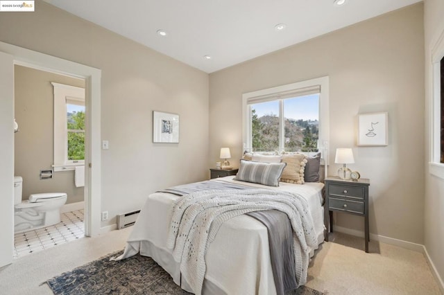 carpeted bedroom with a baseboard radiator and connected bathroom