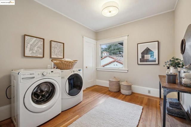 washroom featuring light hardwood / wood-style flooring, ornamental molding, and washer and dryer