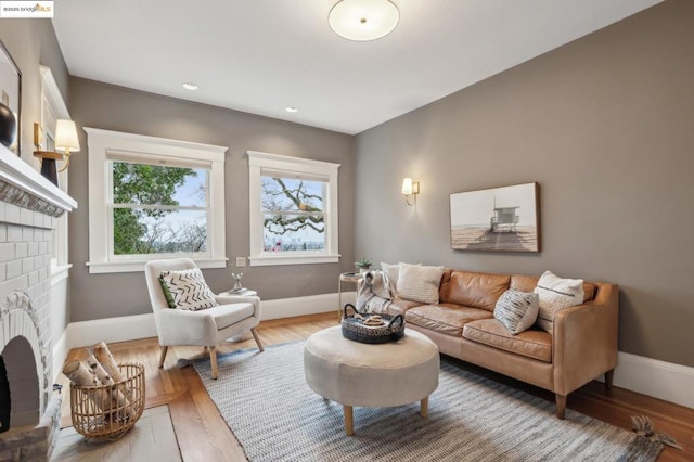 living room featuring a brick fireplace and hardwood / wood-style floors