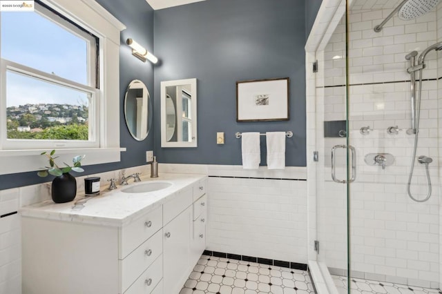 bathroom with vanity, tile walls, and walk in shower