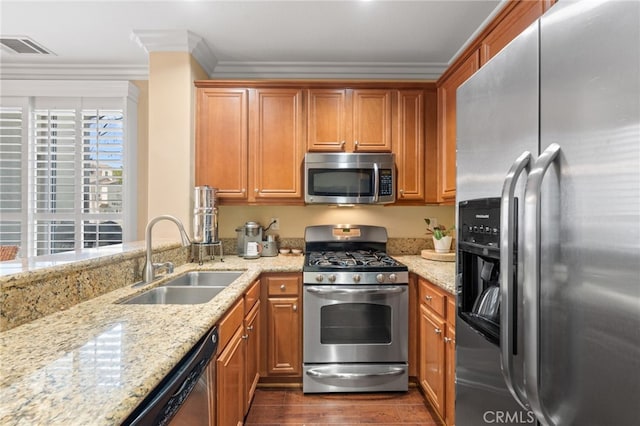 kitchen with sink, appliances with stainless steel finishes, dark hardwood / wood-style floors, light stone counters, and ornamental molding