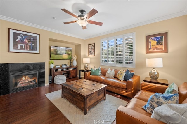 living room with hardwood / wood-style floors, crown molding, a tile fireplace, and ceiling fan