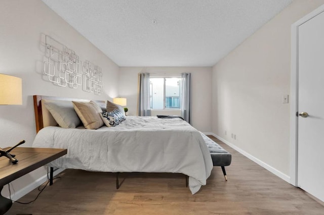 bedroom featuring hardwood / wood-style flooring and a textured ceiling